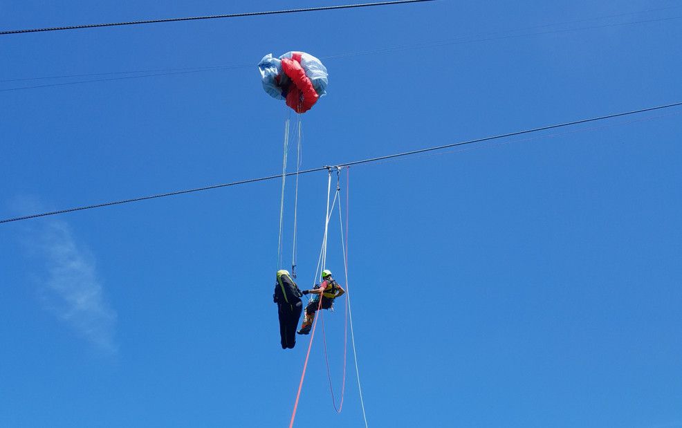 Un parapentiste se retrouve coincé sur un câble de téléphérique